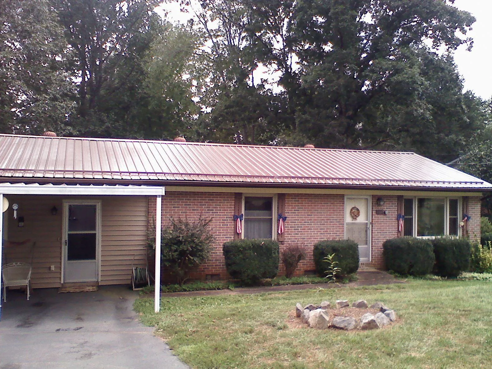 Bronze metal roof and carport on a brick ranch home — Roof Repair work by our crew in Abbeville